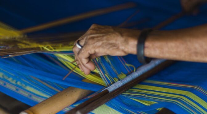 person weaving a mat